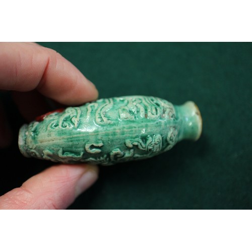 105 - A Chinese green glazed ceramic relief dragon decorated snuff bottle, 2 3/4