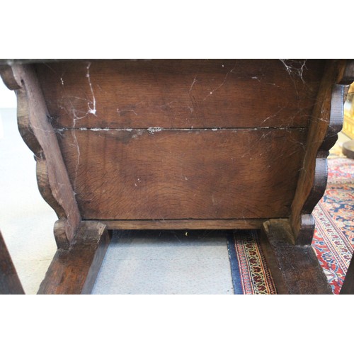 459 - A 17th century carved oak wainscot armchair with scroll panel back, on turned and stretchered suppor... 