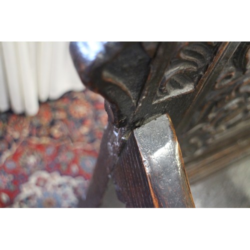 459 - A 17th century carved oak wainscot armchair with scroll panel back, on turned and stretchered suppor... 