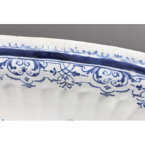 14 - An 18th century Moustiers faience oval charger/serving dish with Berain style Rococo scrollwork with... 