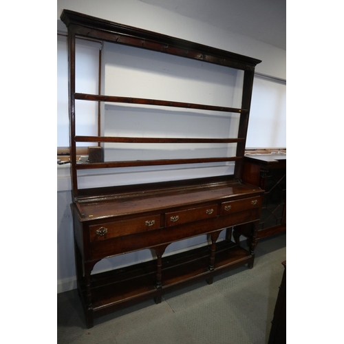 486 - A late 18th century oak dresser, the upper section with open plate shelves over three drawers with b... 