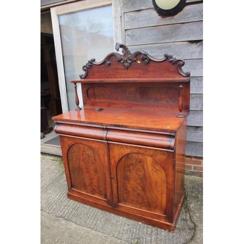 539 - A Victorian mahogany chiffonier with carved ledge back over two drawers and cupboards, on block base... 