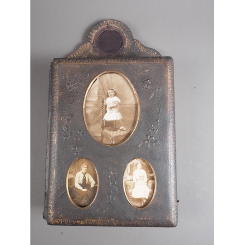 221 - A Victorian photograph album on strut with glazed apertures to cover and pediment, containing a quan... 