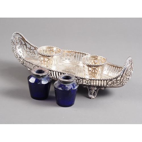 284 - A silver oblong-shaped ink stand with pierced decoration, on four scrolled splayed supports, 9 1/2