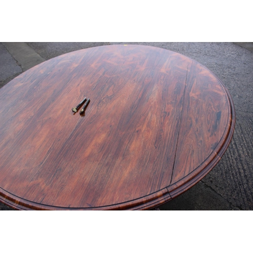 497 - An early 19th century rosewood circular tilt top dining table, on faceted bulbous column and lion pa... 