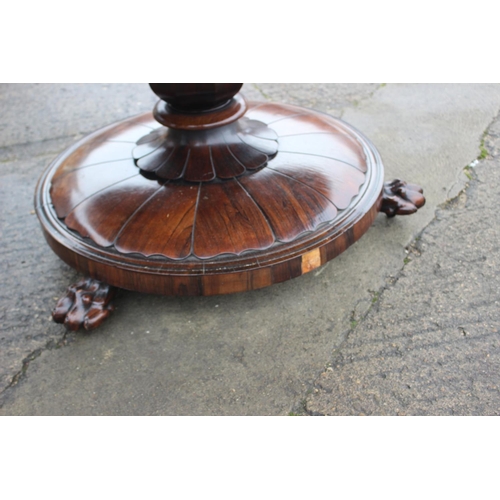 497 - An early 19th century rosewood circular tilt top dining table, on faceted bulbous column and lion pa... 