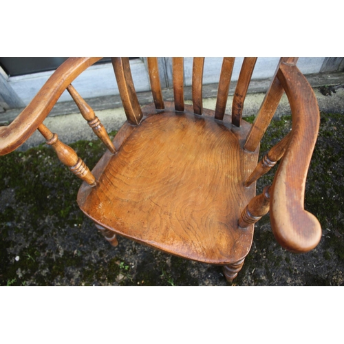 502 - A Windsor lath back farmhouse elbow chair with elm panel seat