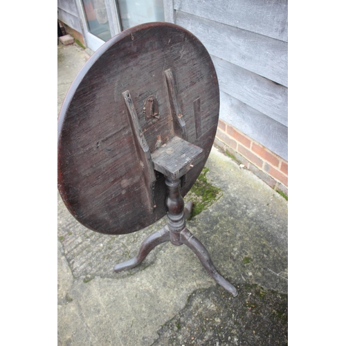 513 - A Georgian provincial mahogany circular tilt top table, on baluster turned oak column and tripod spl... 