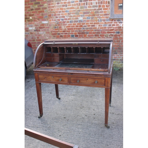 525 - A 19th century mahogany roll top desk with pull-out writing surface, drawers and pigeonholes over tw... 