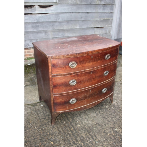 533 - An early 19th century mahogany bowfront chest of three graduated long drawers with oval brass handle... 