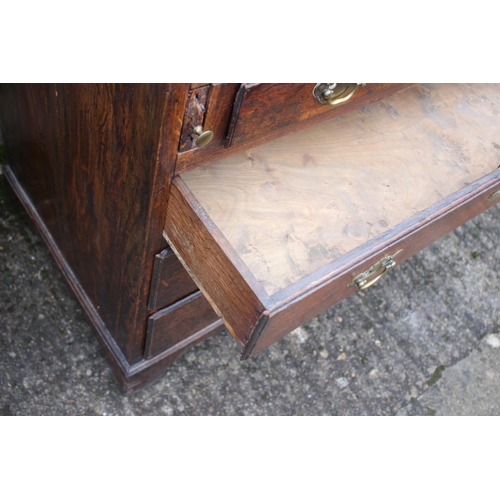 540 - An 18th century oak fall front bureau, the interior fitted drawers, pigeonholes and cupboard over fo... 