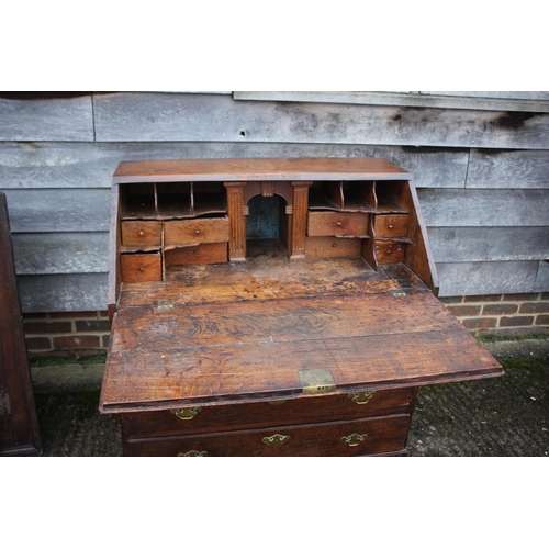 540 - An 18th century oak fall front bureau, the interior fitted drawers, pigeonholes and cupboard over fo... 