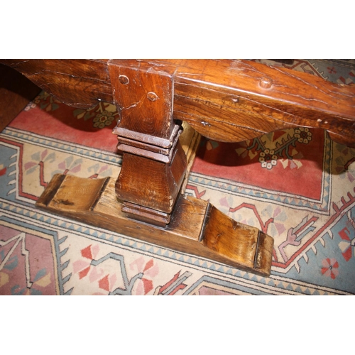 563 - An oak refectory table of early 17th century design with cleated plank top, on twin square baluster ... 