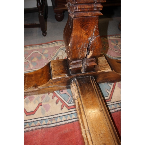 563 - An oak refectory table of early 17th century design with cleated plank top, on twin square baluster ... 