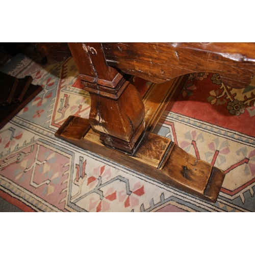 563 - An oak refectory table of early 17th century design with cleated plank top, on twin square baluster ... 