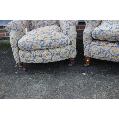 565 - A pair of early 20th century deep seat scroll arm chairs, on square taper castored supports