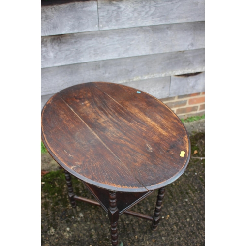 586 - An ebonised oval two-tier occasional table, on bobbin turned support, 20