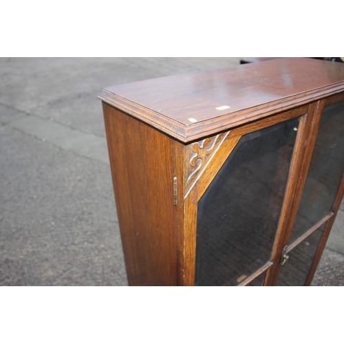 589 - A 1930s oak bookcase enclosed glazed panel doors, on bracket feet, 29