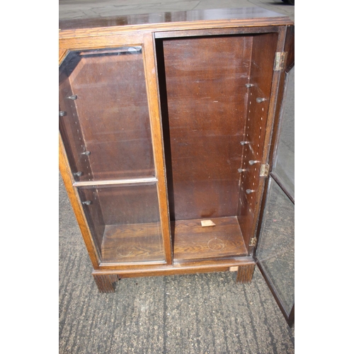 589 - A 1930s oak bookcase enclosed glazed panel doors, on bracket feet, 29