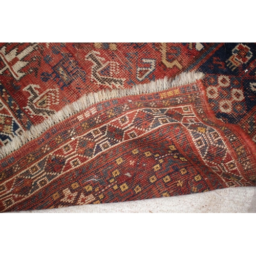 614 - A Qashqai type tribal rug with three medallions on a red ground with flowers, birds, trees and multi... 