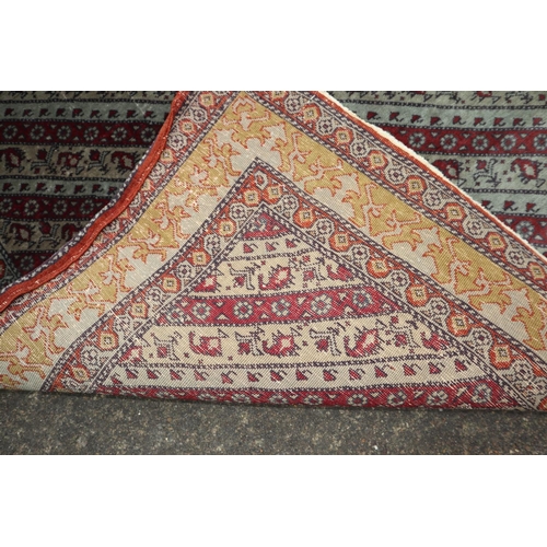 632 - A Persian rug with diagonal shape designs in shades of red, grey, beige and old gold, 55