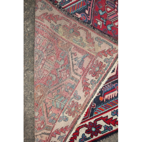 638 - A Caucasian rug with four rosettes on a red ground, 64