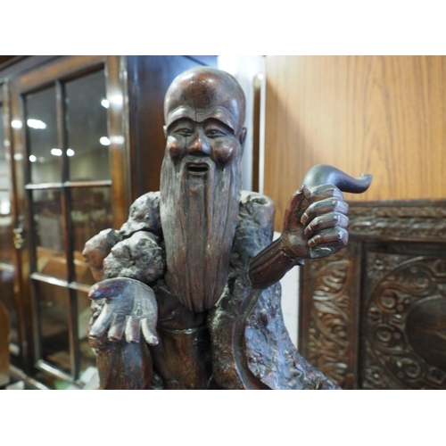 83 - A 19th century Chinese carved root wood figure of Laozi (Lao-Tzu), on ebonised hexagonal table stand... 