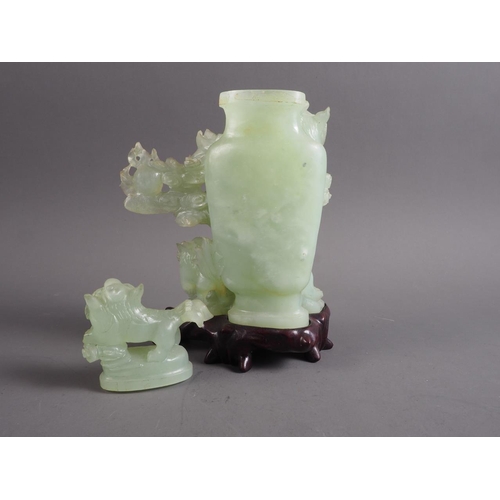 84 - A Chinese carved jade vase and cover modelled as  four Dogs of Fo amongst clouds, on fitted hardwood... 