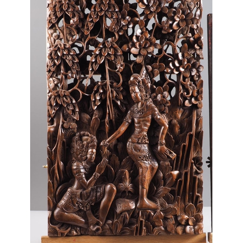 122 - A Balinese hardwood carving, figures amongst trees, 20