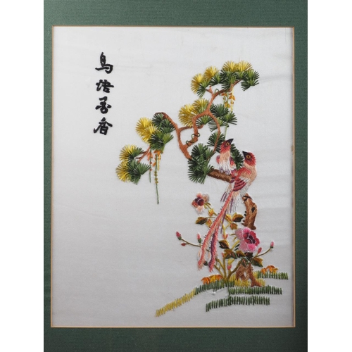 187 - A pair of Chinese embroideries with birds in blooming tree designs, in ebonised frames