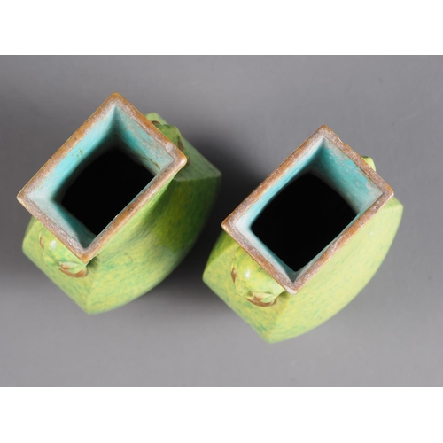 74 - A pair of Chinese green and yellow mottled glaze square-sectioned vases with mask and ring handles, ... 