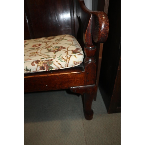 511 - At mid 18th century oak settle with ogee arch top panelled back and loose seat cushion, on cabriole ... 