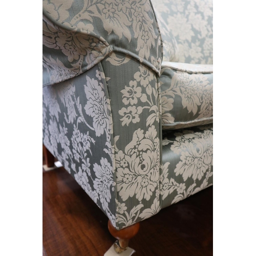 604 - A Wesley Barrel two-seat settee, upholstered in a light blue floral brocade, on castored supports, 7... 