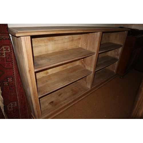 608 - A 19th century stripped pine bookcase, the upper section enclosed astragal glazed panel doors over o... 