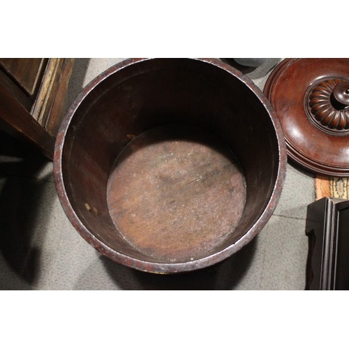 602 - A mahogany and brass mounted cylindrical shaped lidded log box with mask and ring handles, on ball a... 