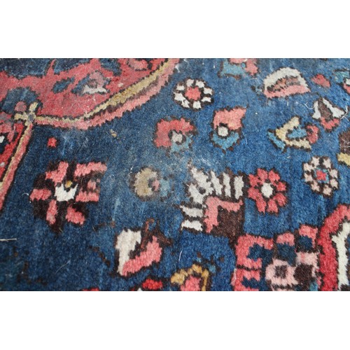 618 - A Persian city rug with all-over tendril and floral design on a red ground, 83