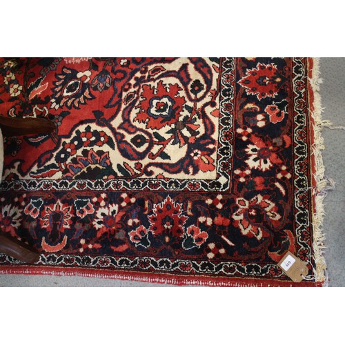 619 - A Persian city rug with all-over floral design on a red ground, 83