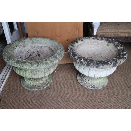 648 - A pair of cast stone urns