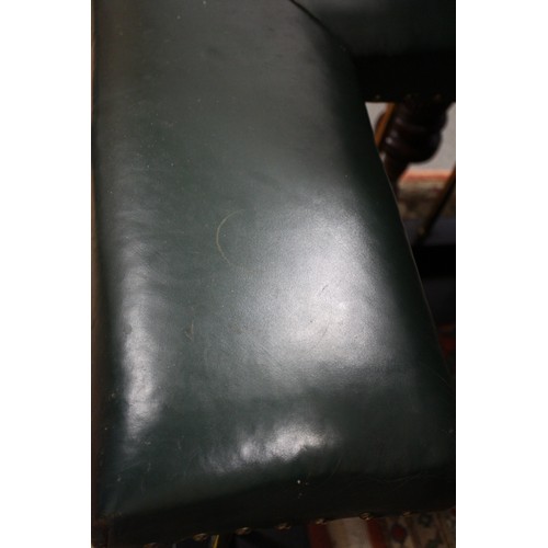 573 - A brass and ebonised club fender, upholstered in a green leather, outside measurements: 83