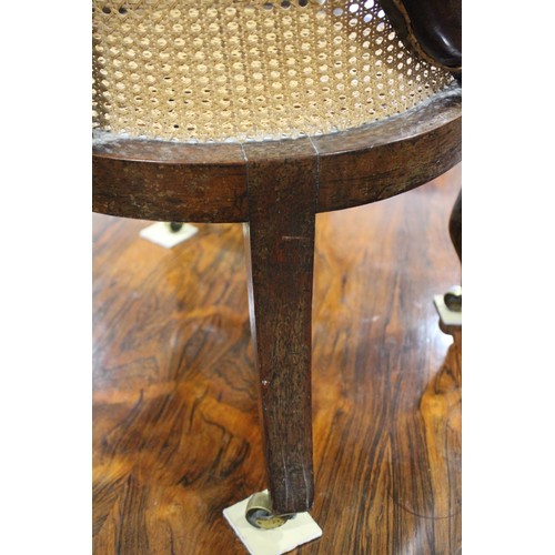 518 - An early 19th century rosewood cane seat and back low seat nursing chair, on cabriole castored suppo... 