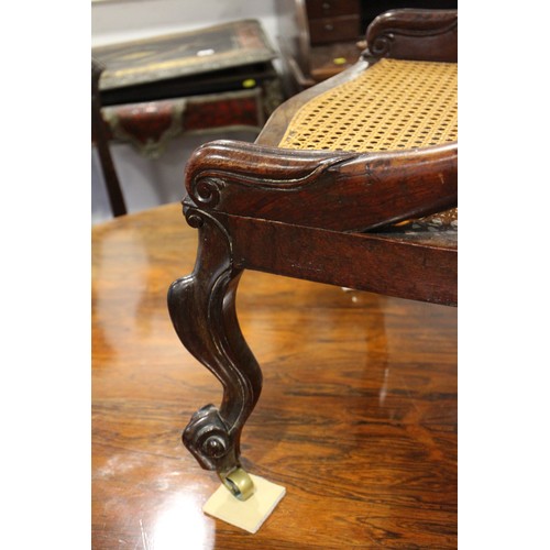 518 - An early 19th century rosewood cane seat and back low seat nursing chair, on cabriole castored suppo... 