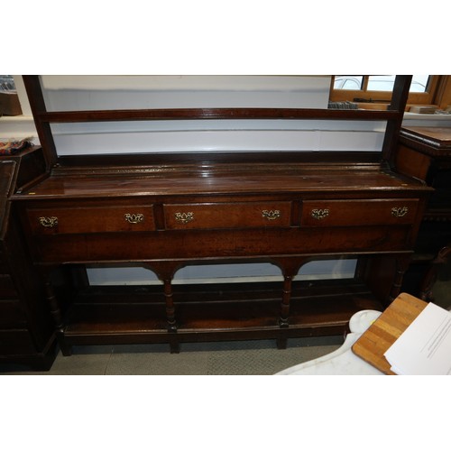 486 - A late 18th century oak dresser, the upper section with open plate shelves over three drawers with b... 