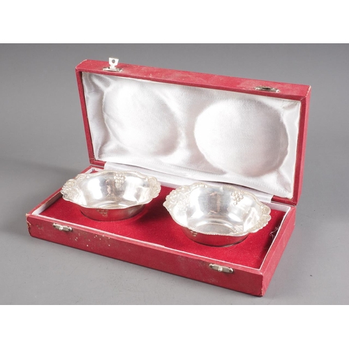 364 - A pair of white metal dishes with embossed swag, scrolled and grape decoration, stamped 