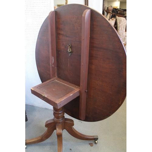 534 - A 19th century mahogany circular topped tilt top table, on quadruple splayed and castored supports, ... 