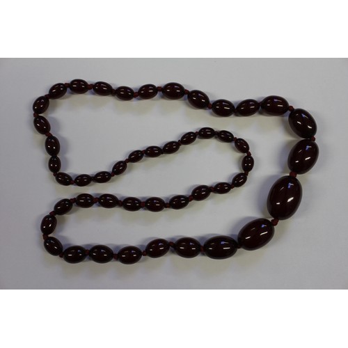 388 - A string of cherry amber Bakelite graduated oval beads, largest 29mm wide, 61g, and a jade coloured ... 