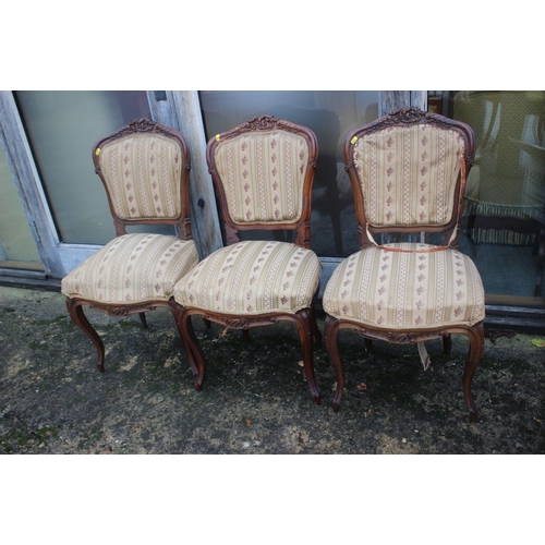 555 - A set of three French carved walnut side chairs with padded seats and backs, on cabriole supports an... 