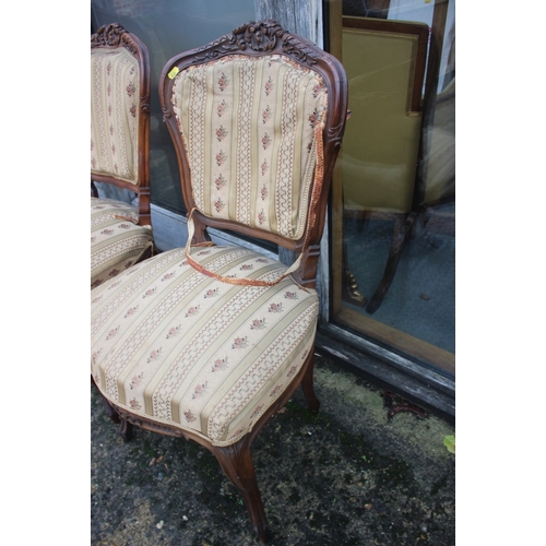 555 - A set of three French carved walnut side chairs with padded seats and backs, on cabriole supports an... 