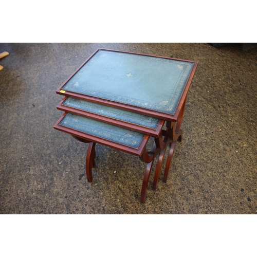 656 - A nest of three mahogany leather top x-frame occasional tables, largest 22
