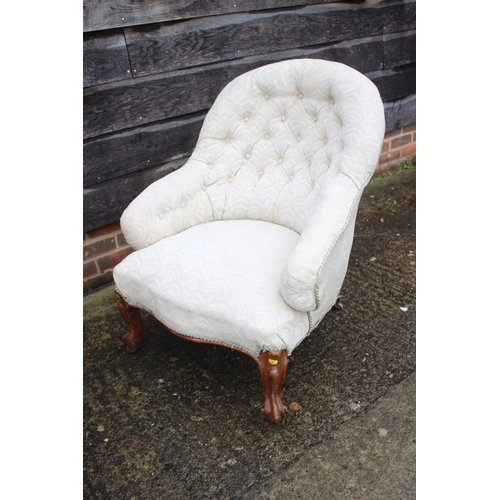 629 - A button back open armchair, upholstered in a patterned fabric, on cabriole castored supports