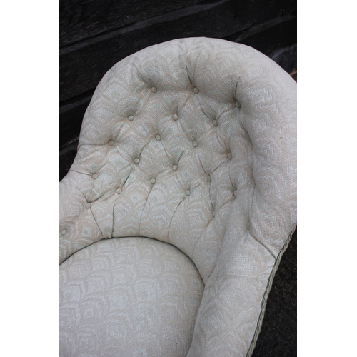 629 - A button back open armchair, upholstered in a patterned fabric, on cabriole castored supports